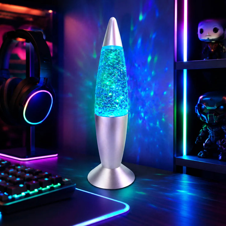 Rocket lava lamp glowing blue on a gaming desk